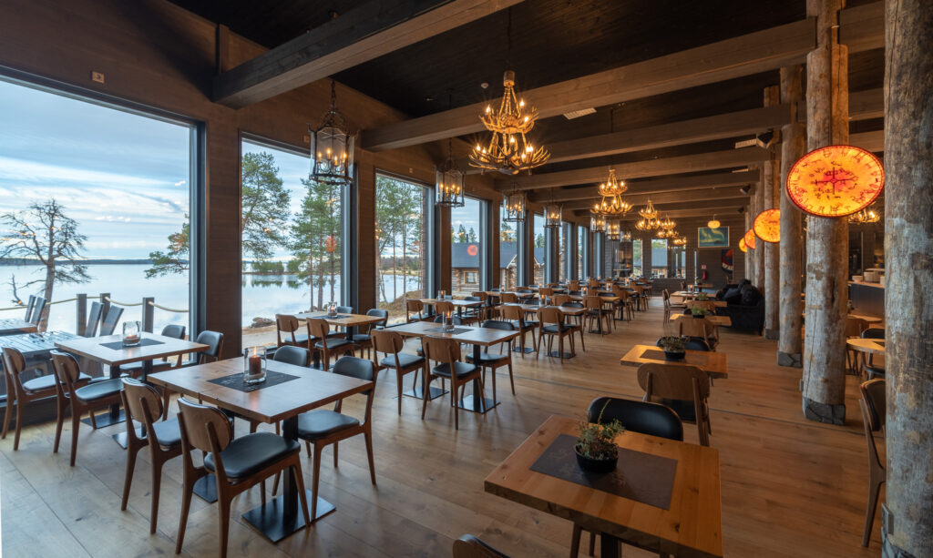 Tilava, maalaismainen ravintola, jossa on suuret ikkunat, joista avautuu näkymät luonnonkauniille järvelle ja puille, puulattiat ja -palkit, modernit puupöydät ja -tuolit sekä lämpimät, koristeelliset riippuvalot.