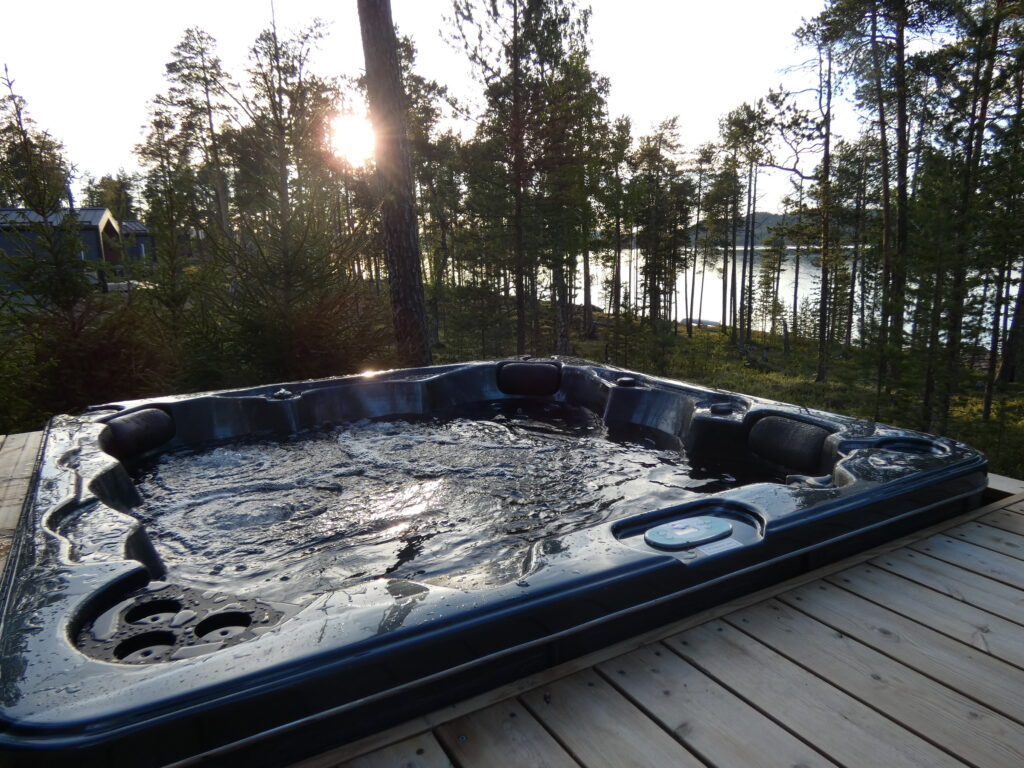 Puuterassilla, mäntyjen ympäröimänä, sijaitsee poreallas, jonka vesi aaltoilee lempeästi, ja josta avautuu näkymä järvelle auringonlaskun aikaan.